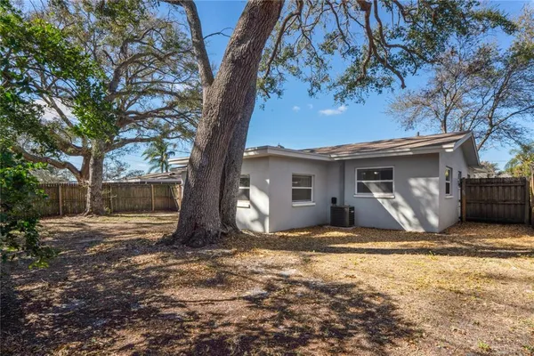 a view of house with backyard and trees