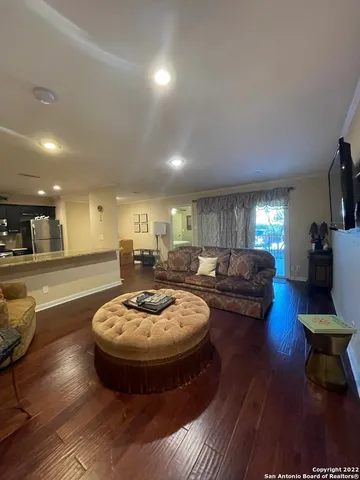 a living room with furniture and a wooden floor