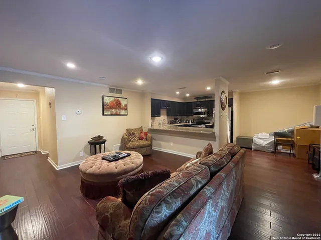 a living room with furniture and wooden floor