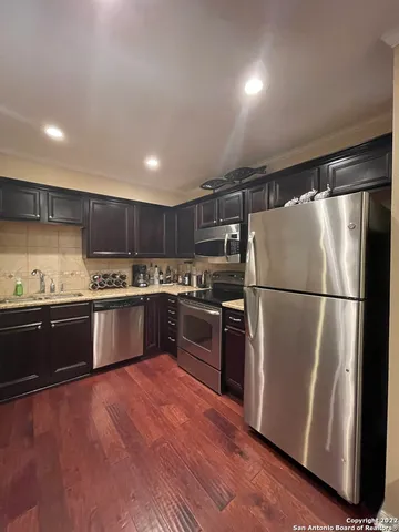 a kitchen with granite countertop stainless steel appliances and refrigerator