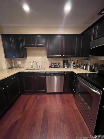 a kitchen with a sink a stove and cabinets