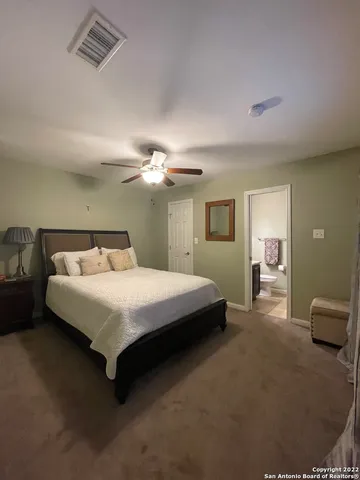 a spacious bedroom with a bed and a chandelier