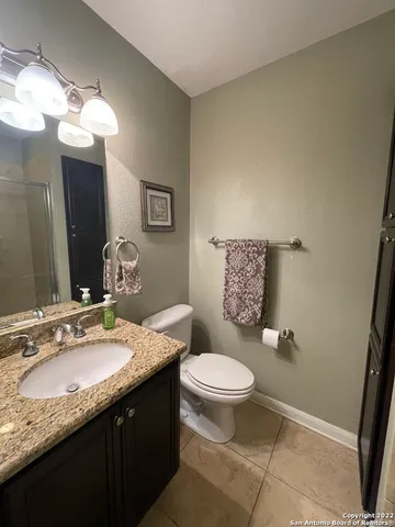 a bathroom with a granite countertop sink a toilet and a mirror