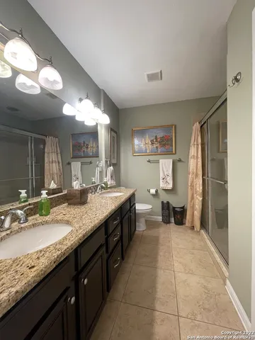 a large bathroom with a granite countertop sink a toilet and a mirror