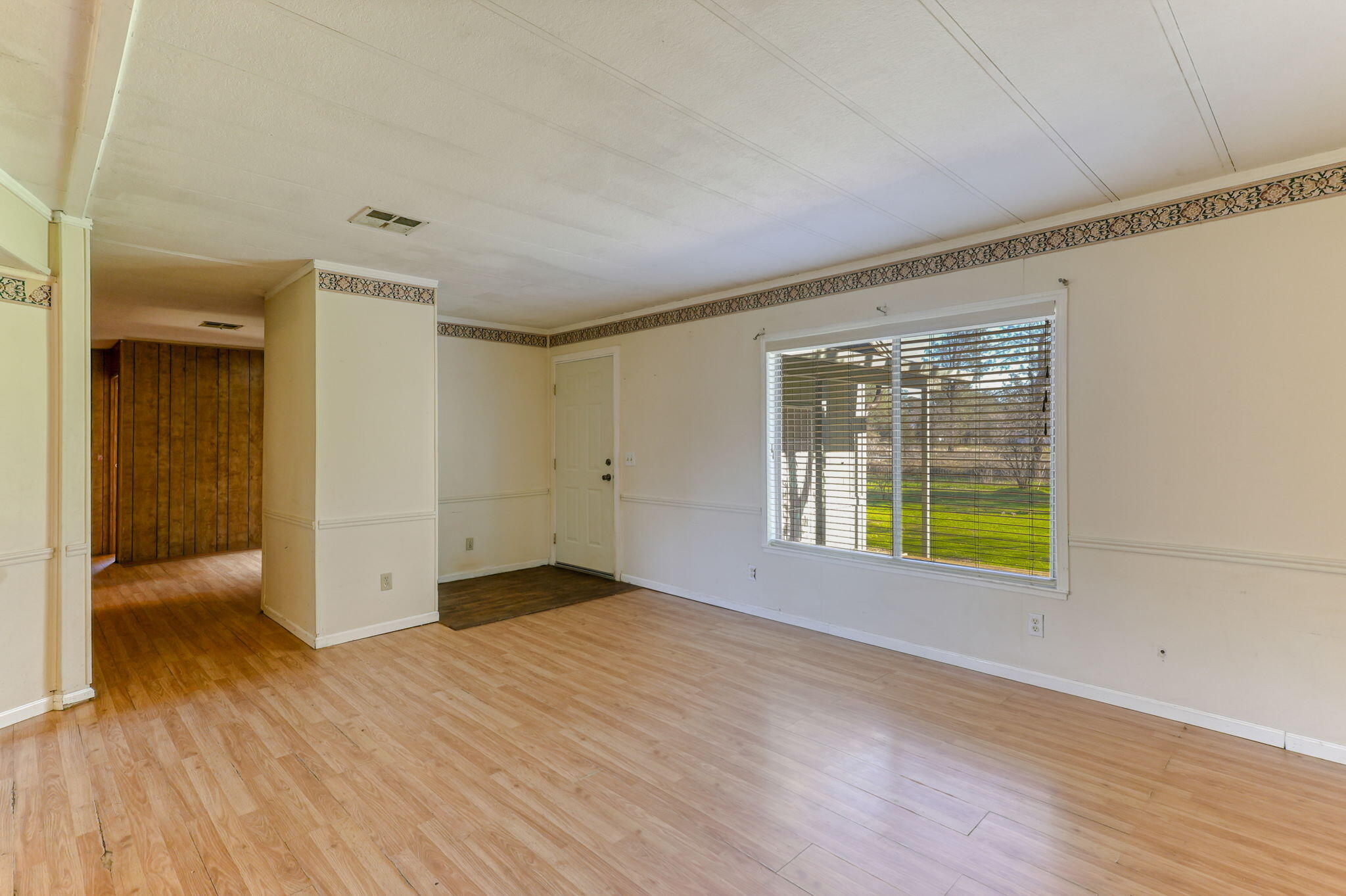 5082 Happy Valley Road Anderson, CA 96007 - Photo 12 of 66 a view of an empty room with wooden floor and a window