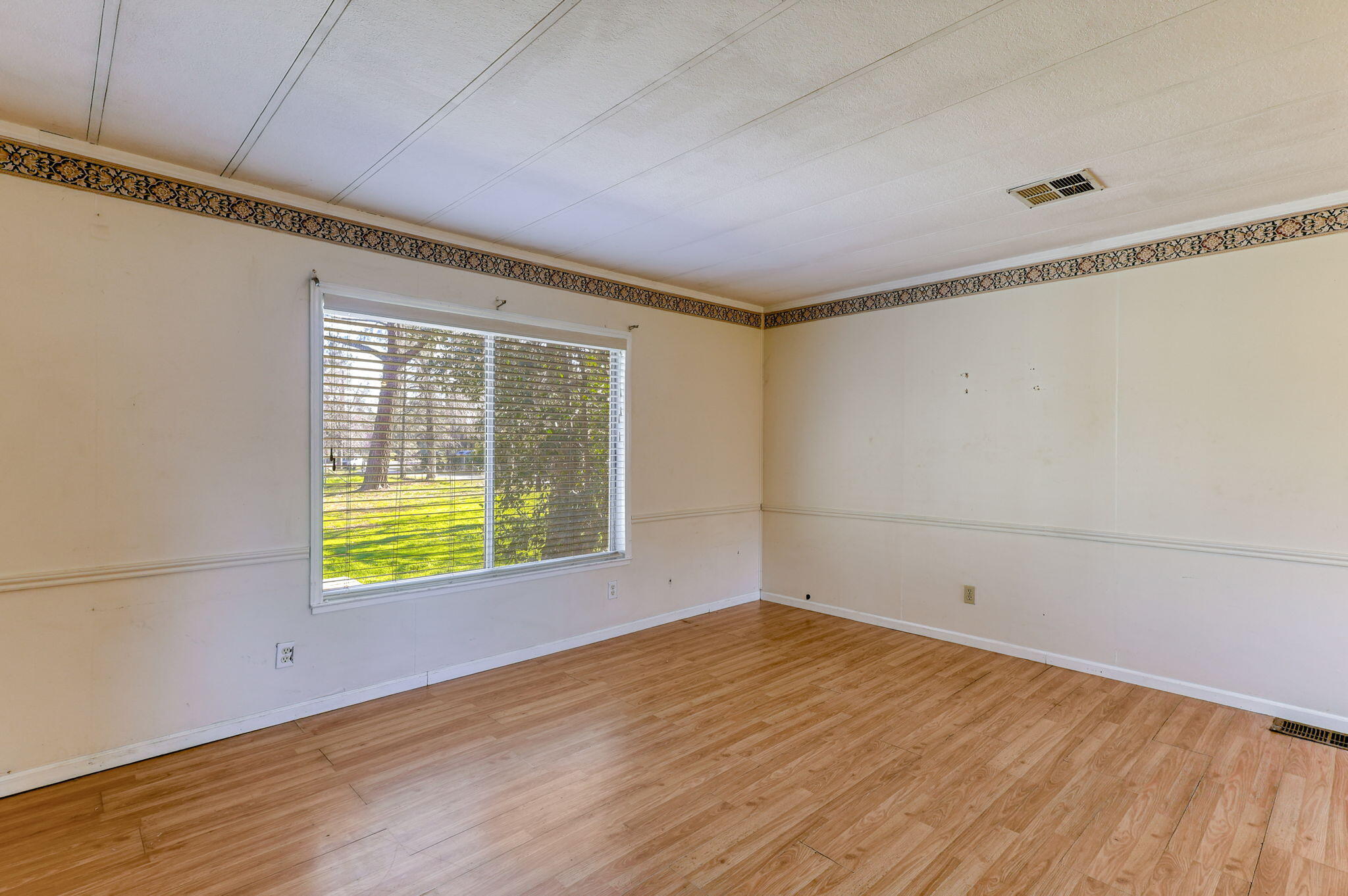 5082 Happy Valley Road Anderson, CA 96007 - Photo 7 of 66 a view of an empty room with wooden floor and a window