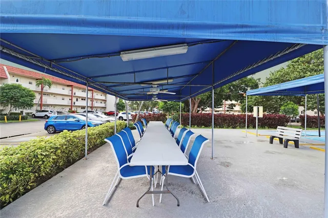 a view of a patio with a table and chairs under a large umbrella