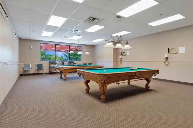 a room with pool table and windows