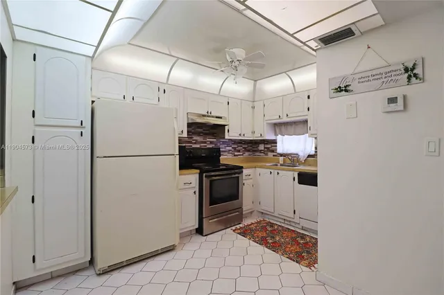 a kitchen with cabinets and refrigerator