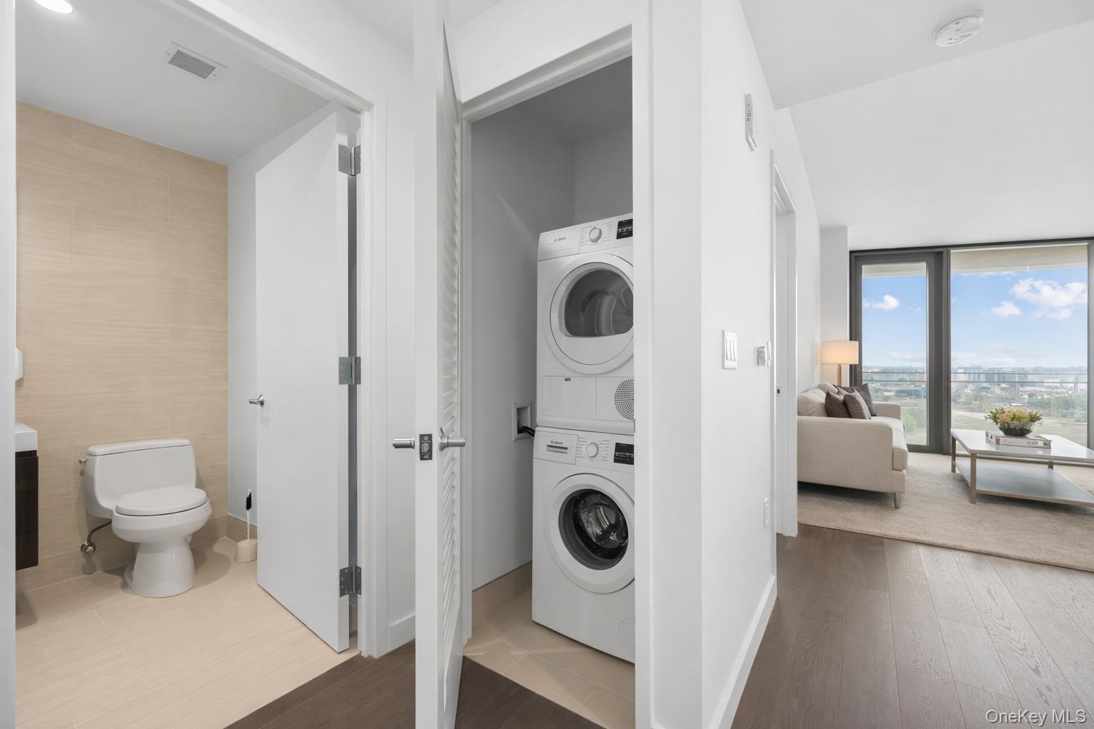 131-05 40 Road, Unit 18H Queens, NY 11354 - Photo 13 of 14 a view of a bedroom with washer and dryer