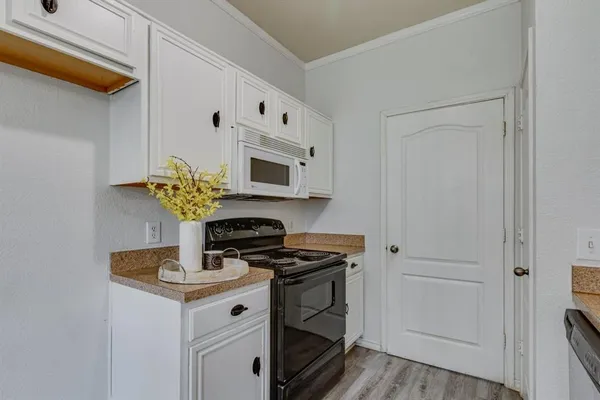 a kitchen with stainless steel appliances a white cabinets and stove top oven