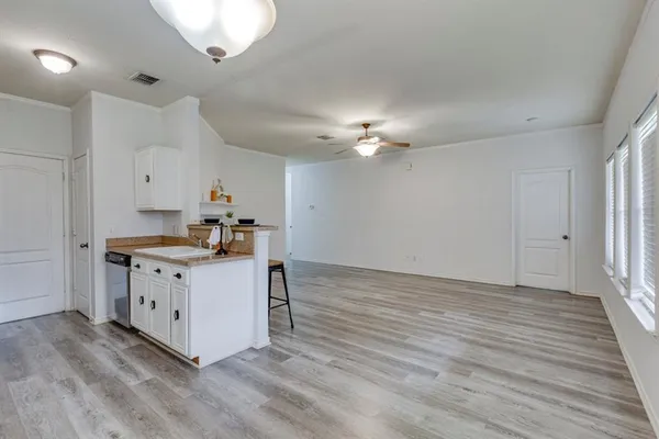 a kitchen with stainless steel appliances granite countertop a white cabinets and wooden floor