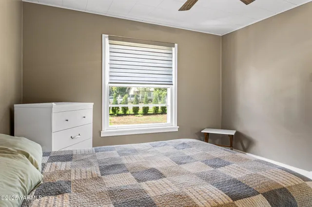 a bathroom with a sink a toilet a window and shower