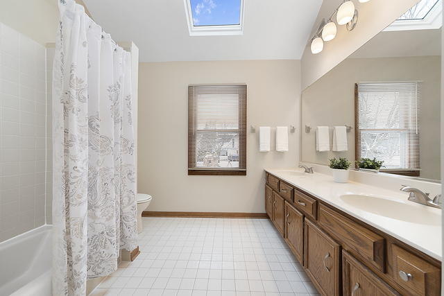 1940 Slippery Rock Road Naperville, IL 60565 - Photo 20 of 28 a bathroom with a double vanity sink a large mirror and a bathtub