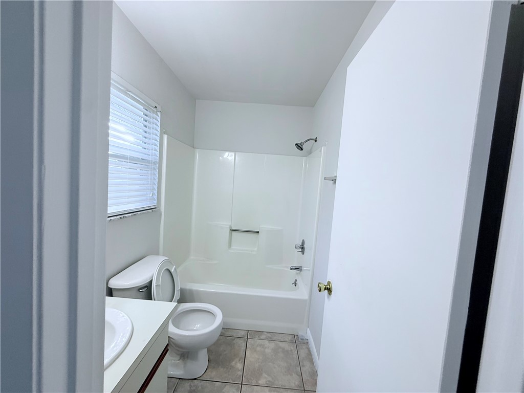 224 Georgia Street Vero Beach, FL 32962 - Photo 18 of 23 a bathroom with a granite countertop toilet a sink and bathtub