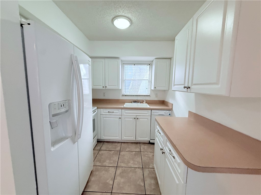 224 Georgia Street Vero Beach, FL 32962 - Photo 9 of 23 a kitchen with a sink a refrigerator and cabinets