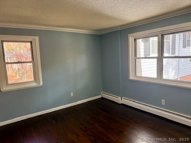 a view of a room with wooden floor and a window
