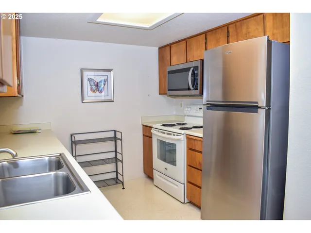 a kitchen with stainless steel appliances a refrigerator stove and sink