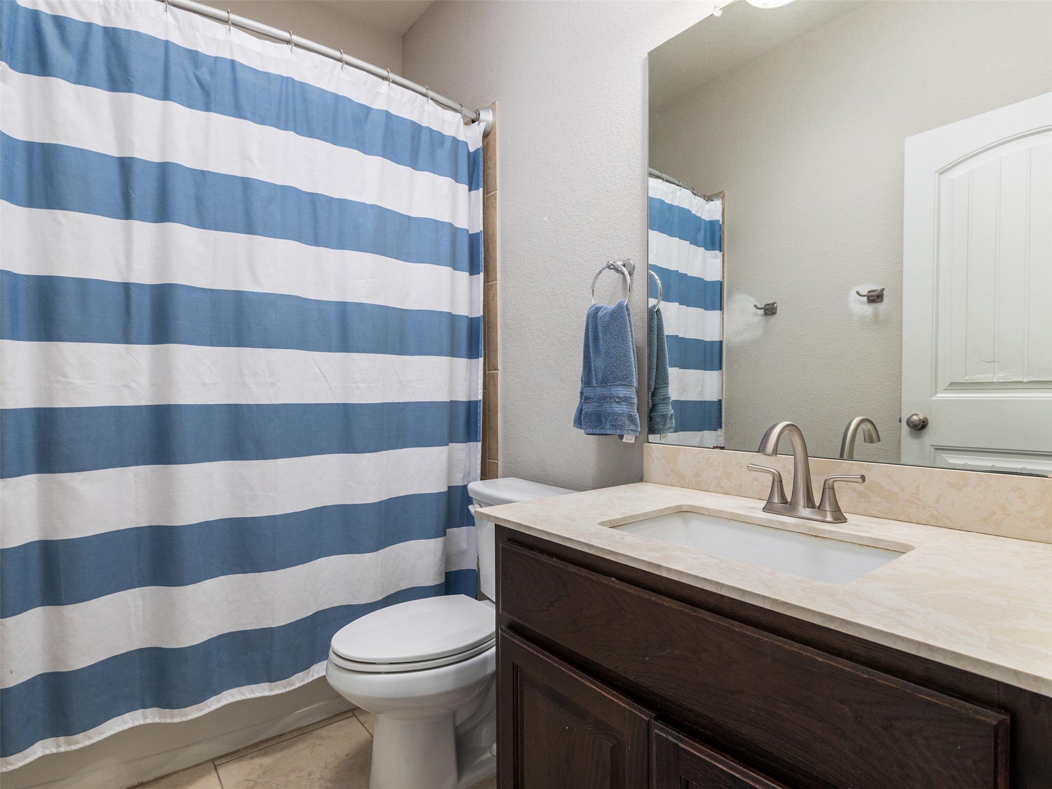 717 Blue Agave Lane Georgetown, TX 78626 - Photo 18 of 28 a bathroom with a sink a toilet a mirror and shower curtain