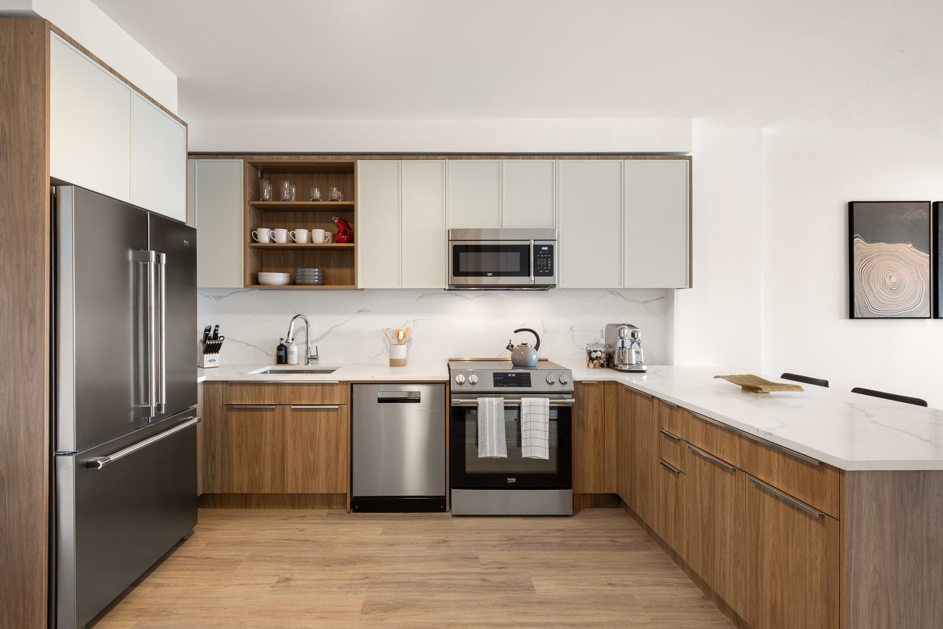 a kitchen with stainless steel appliances granite countertop a refrigerator a sink a stove a microwave and wooden cabinets