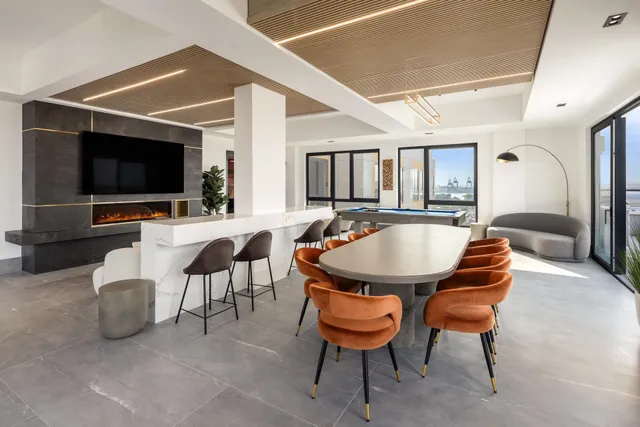 a living room with furniture a large window and kitchen view