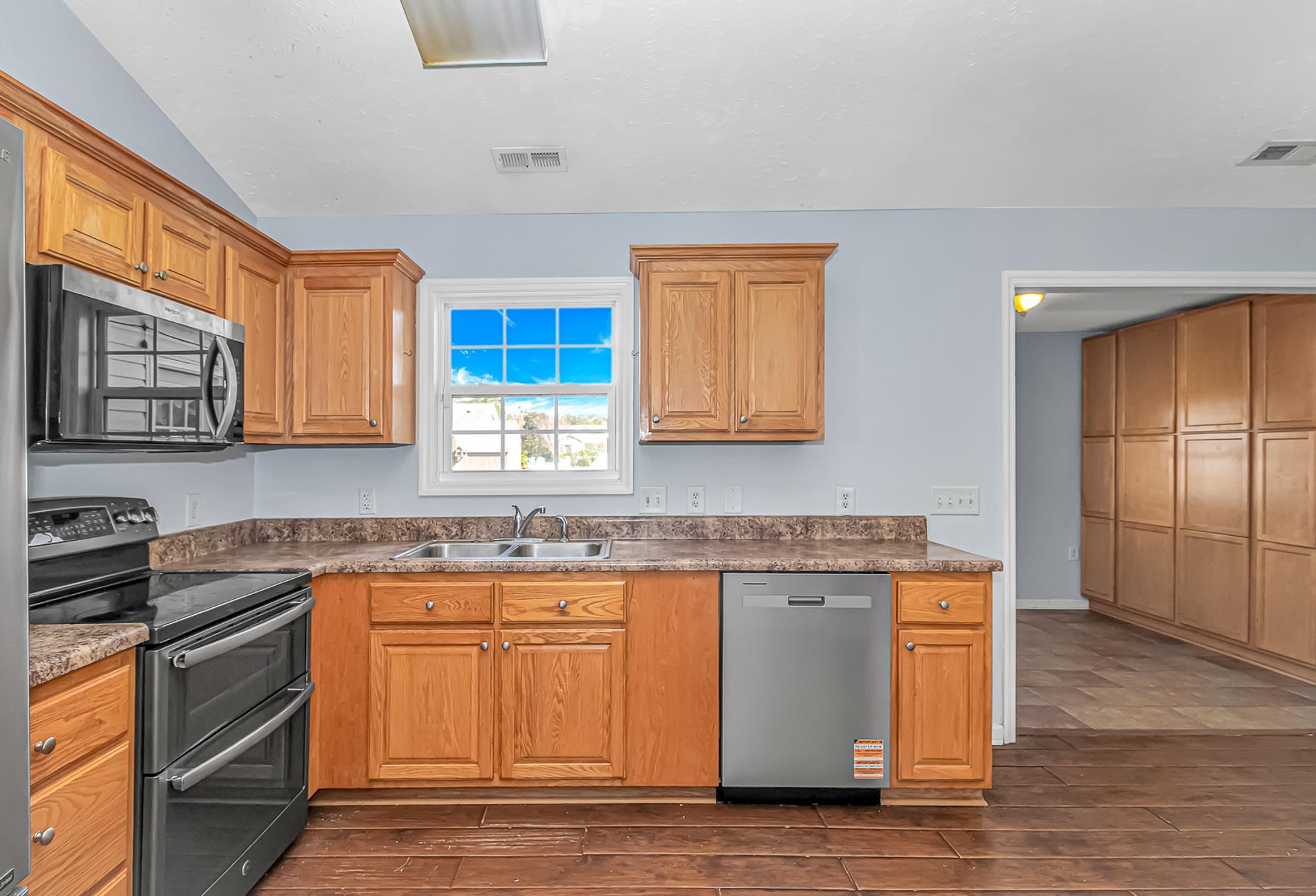 1012 Cadbury Court Conway, SC 29527 - Photo 13 of 40 Kitchen featuring appliances with stainless steel finishes, lofted ceiling, brown cabinetry, and dark wood-style floors