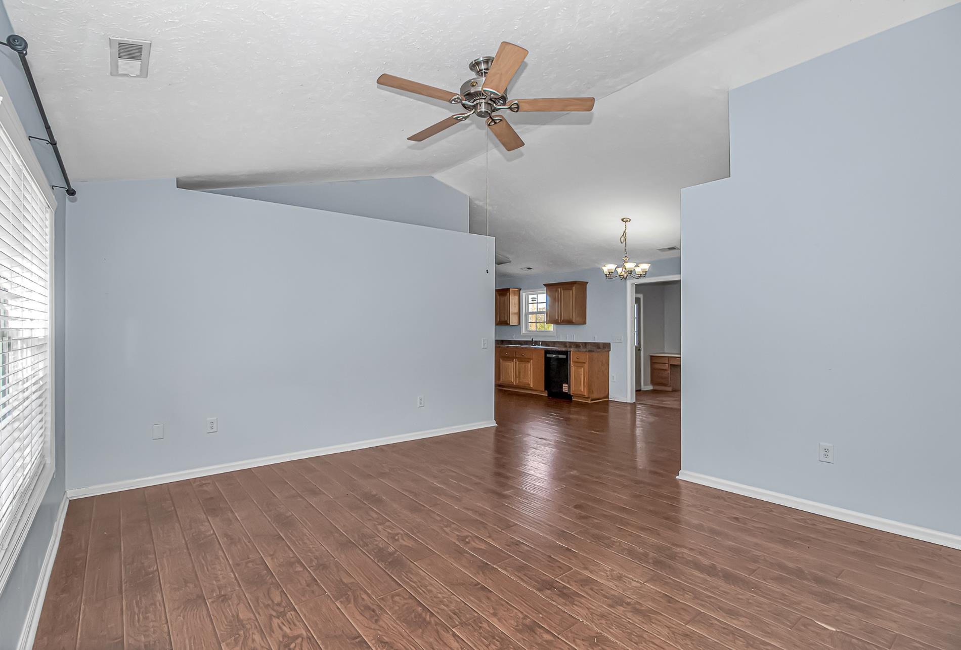 1012 Cadbury Court Conway, SC 29527 - Photo 9 of 40 Unfurnished living room featuring a chandelier, vaulted ceiling, dark wood-style floors, a ceiling fan, and a textured ceiling