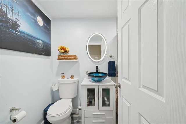 a bathroom with a toilet a sink and a mirror