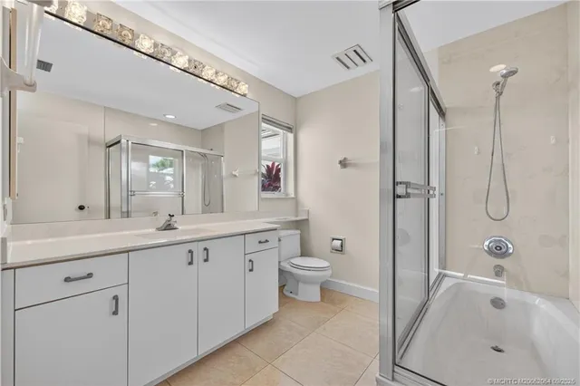 a spacious bathroom with a granite countertop sink a toilet and shower