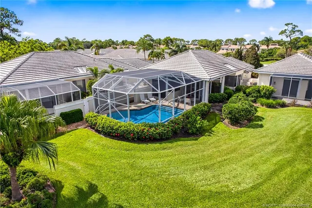 a view of a big house with a big yard and potted plants