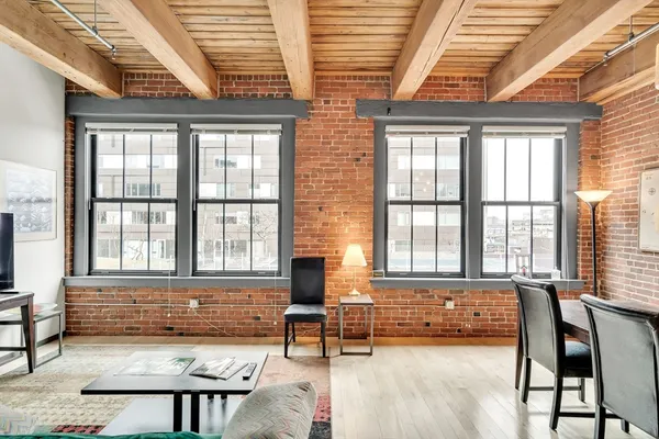 a living room with furniture and two window