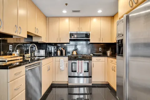 a kitchen with stainless steel appliances granite countertop a refrigerator sink and cabinets