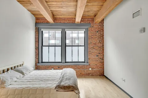 a view of a bedroom with a bed and a window