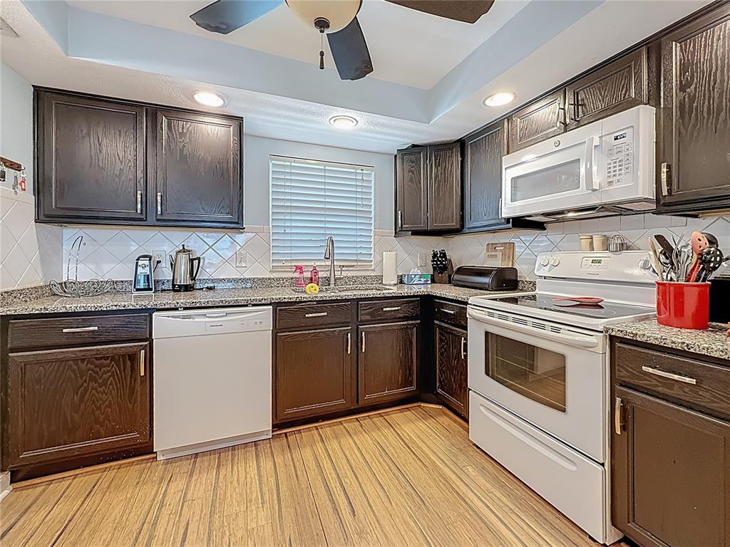 4725 Cove Circle, Unit 908 St. Petersburg, FL 33708 - Photo 16 of 61 a kitchen with stainless steel appliances granite countertop wooden cabinets granite counter tops and a hard wood floors
