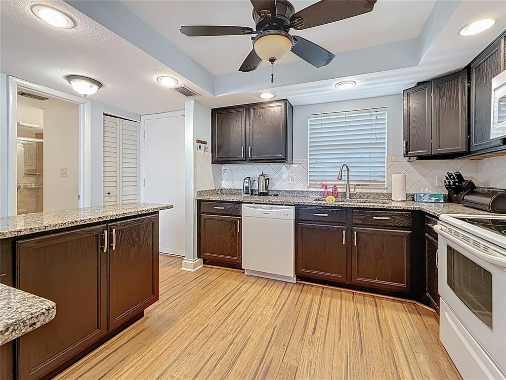 4725 Cove Circle, Unit 908 St. Petersburg, FL 33708 - Photo 17 of 61 a kitchen with granite countertop a sink cabinets stainless steel appliances and a window