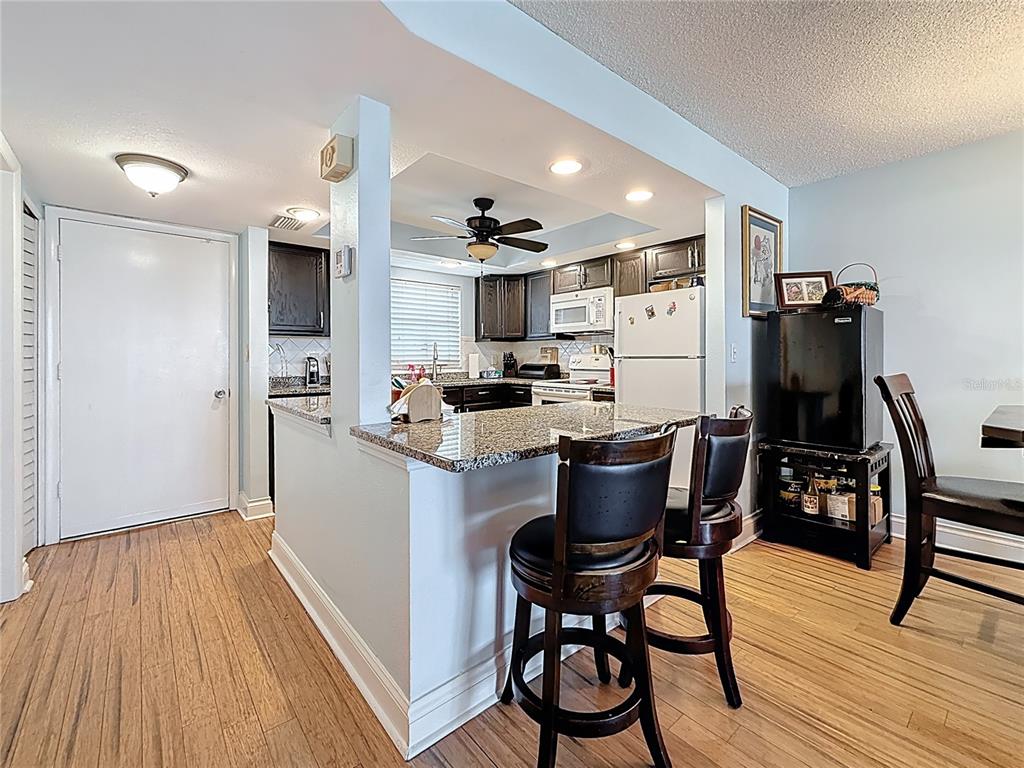4725 Cove Circle, Unit 908 St. Petersburg, FL 33708 - Photo 18 of 61 a kitchen with a table and chairs in it
