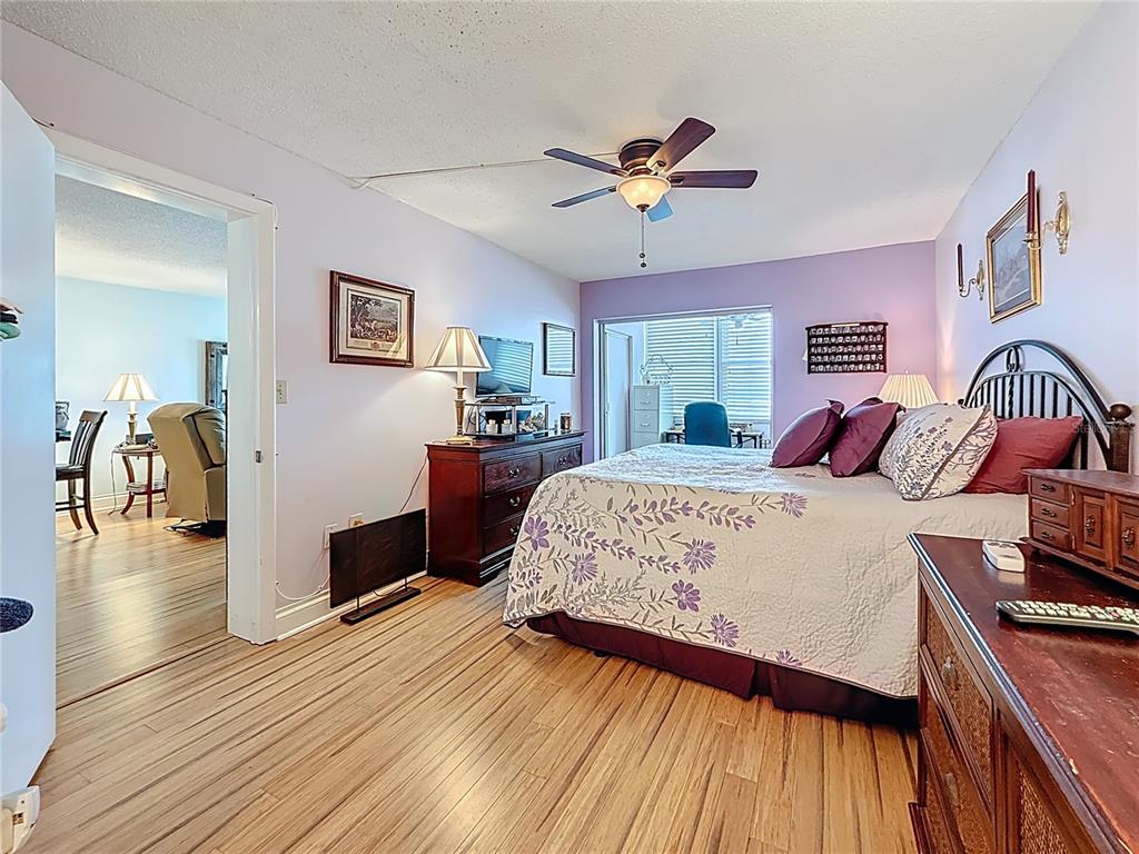 4725 Cove Circle, Unit 908 St. Petersburg, FL 33708 - Photo 25 of 61 a bedroom with a bed and wooden floor