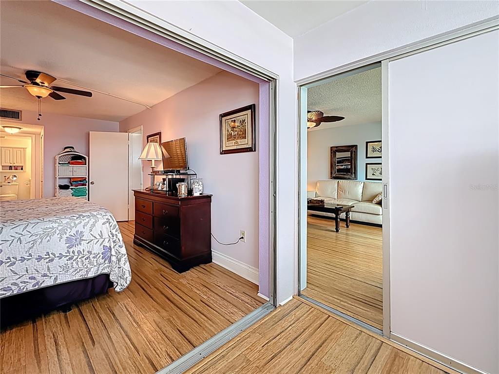 4725 Cove Circle, Unit 908 St. Petersburg, FL 33708 - Photo 28 of 61 a bedroom with a bed and wooden floor