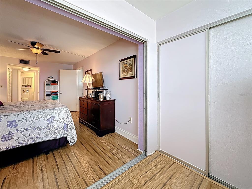 4725 Cove Circle, Unit 908 St. Petersburg, FL 33708 - Photo 29 of 61 a bedroom with a bed and wooden floor