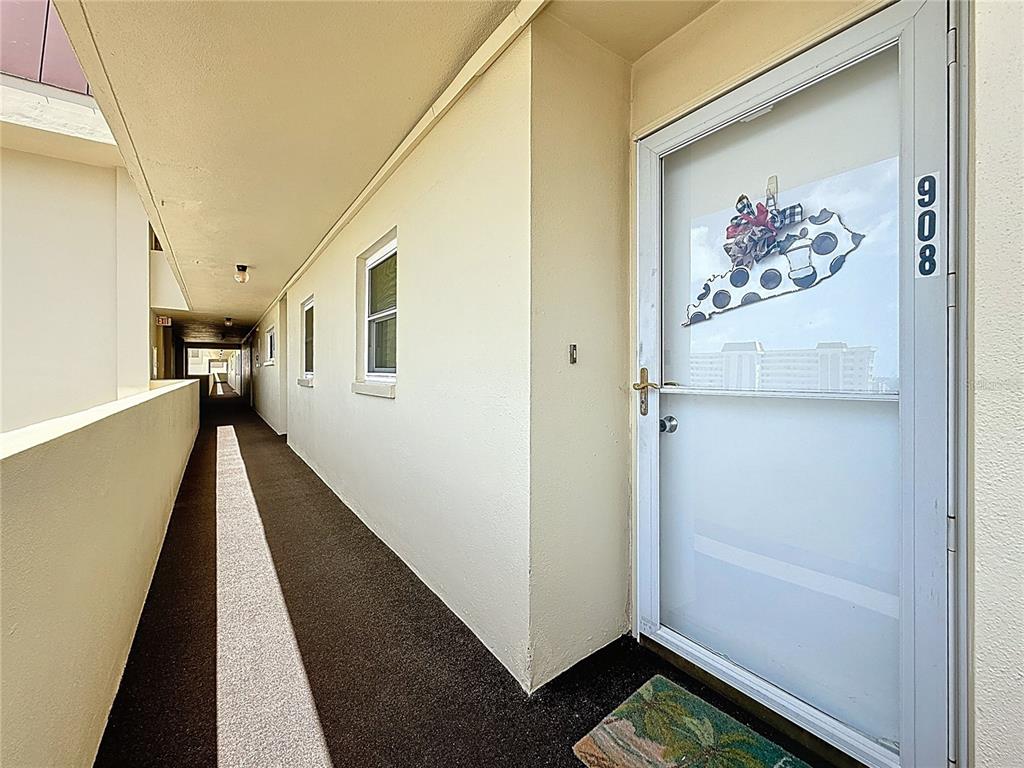 4725 Cove Circle, Unit 908 St. Petersburg, FL 33708 - Photo 4 of 61 a view of a hallway with paintings on the wall