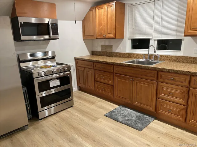 a kitchen with stainless steel appliances granite countertop a stove a sink and a microwave