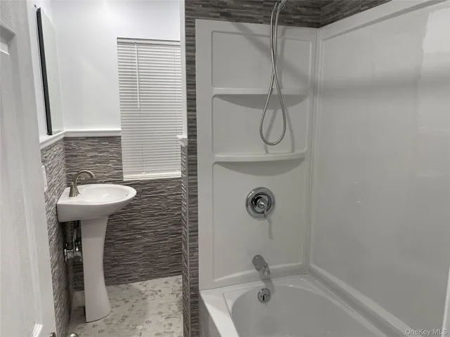 a bathroom with a sink a mirror and shower