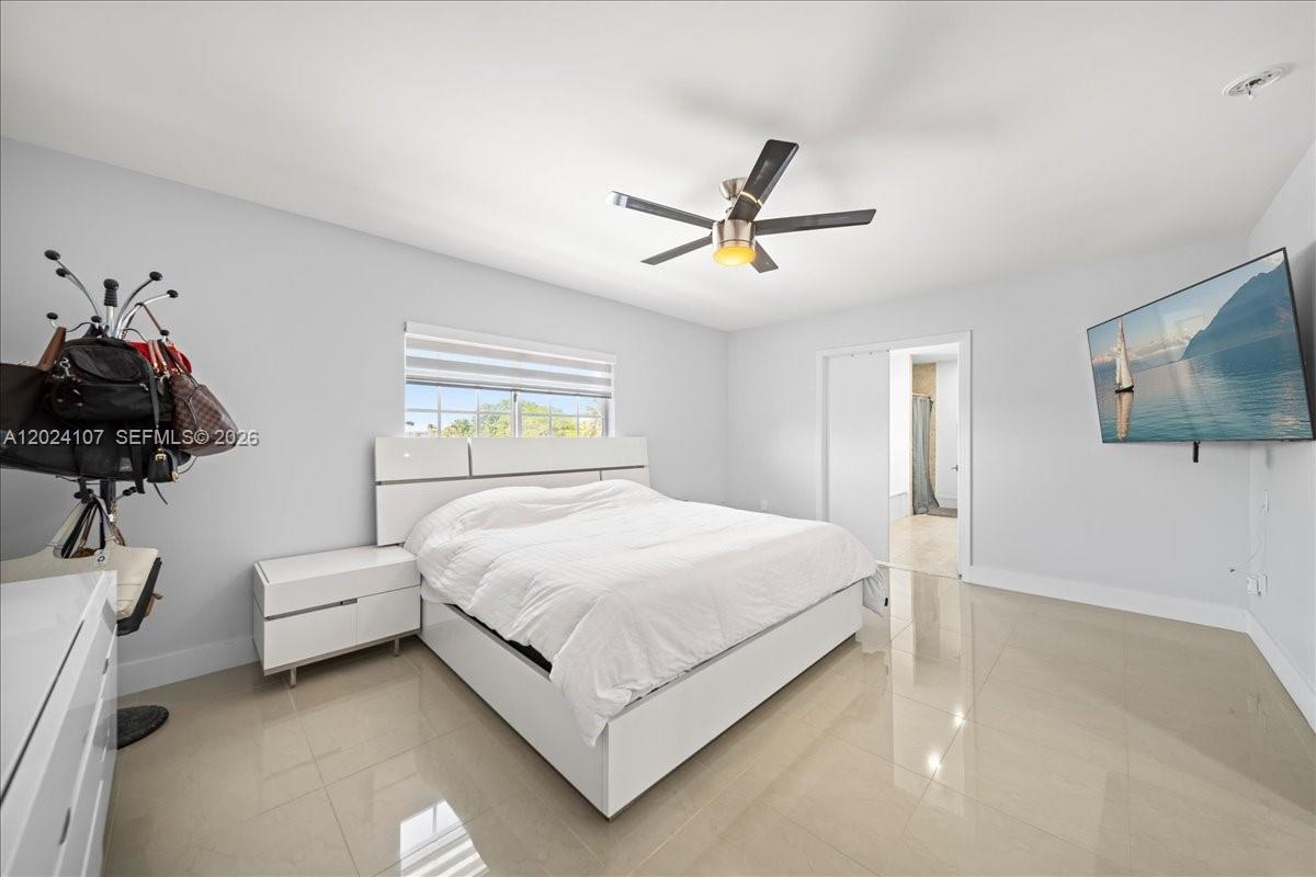15341 Southwest 36th Street Miami, FL 33185 - Photo 24 of 56 a bedroom with a bed and a chandelier