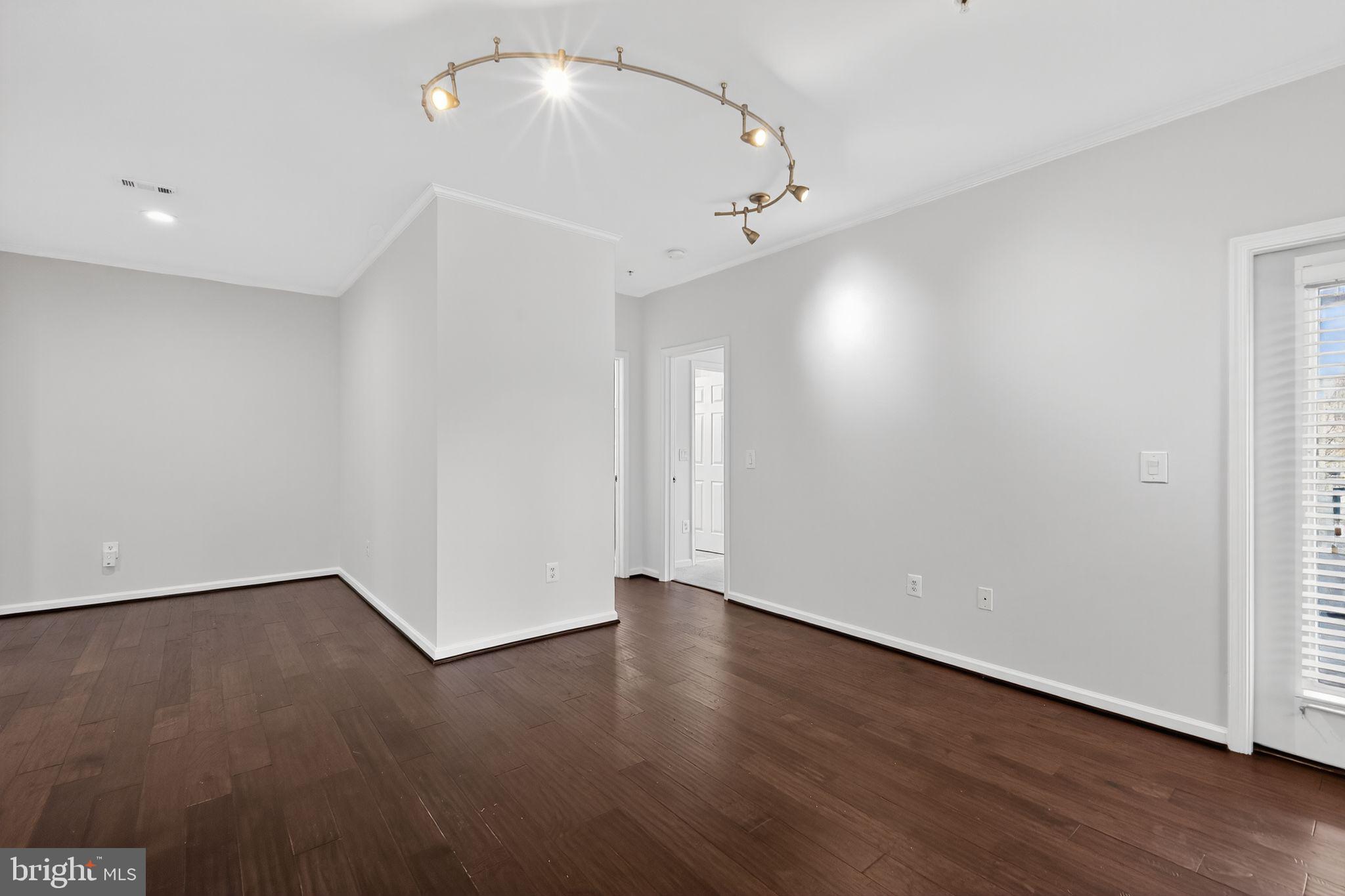 12016 Taliesin Place, Unit 26 Reston, VA 20190 - Photo 12 of 30 an empty room with wooden floor and windows