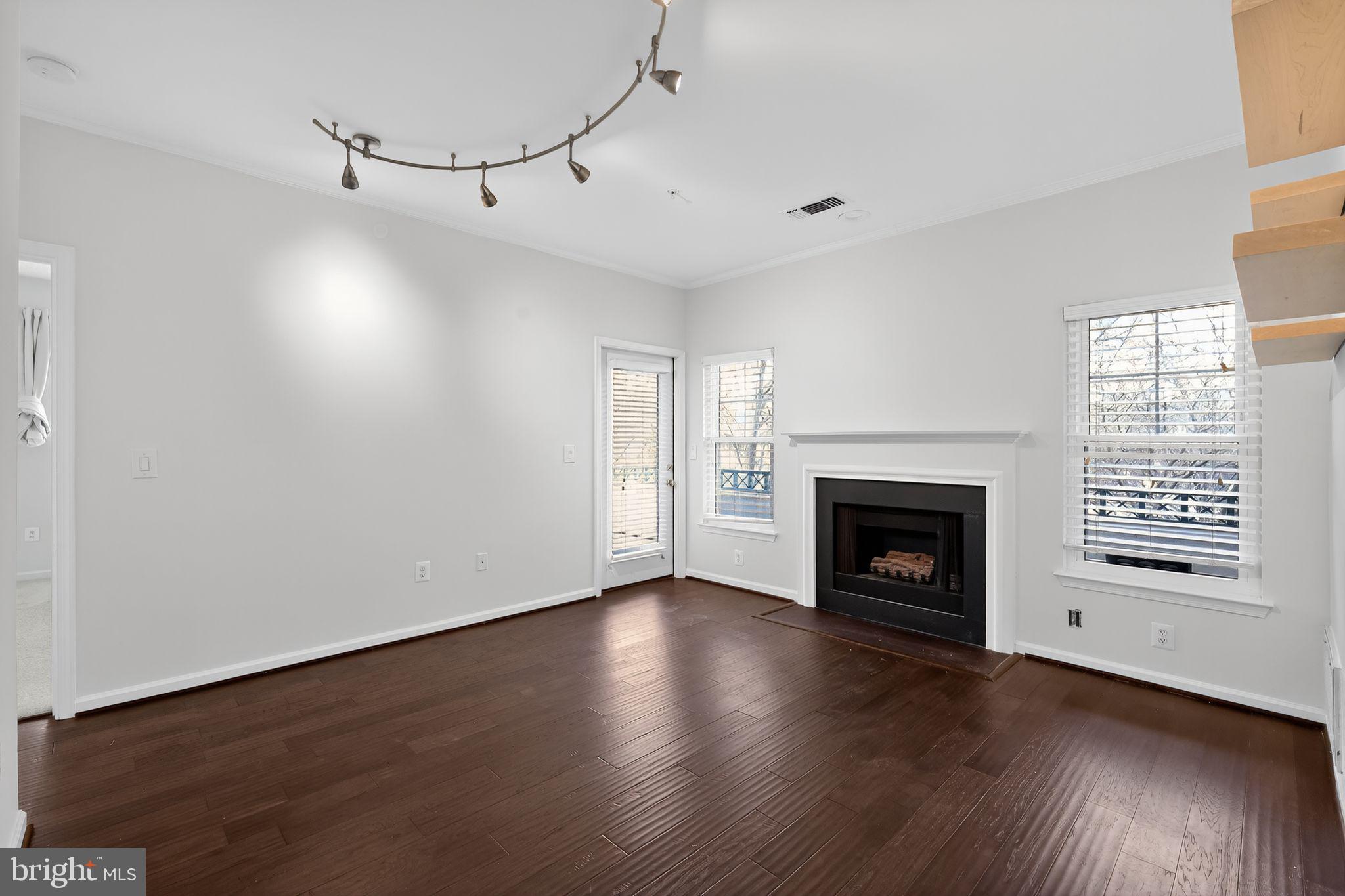 12016 Taliesin Place, Unit 26 Reston, VA 20190 - Photo 15 of 30 a view of a livingroom with wooden floor a fireplace and windows
