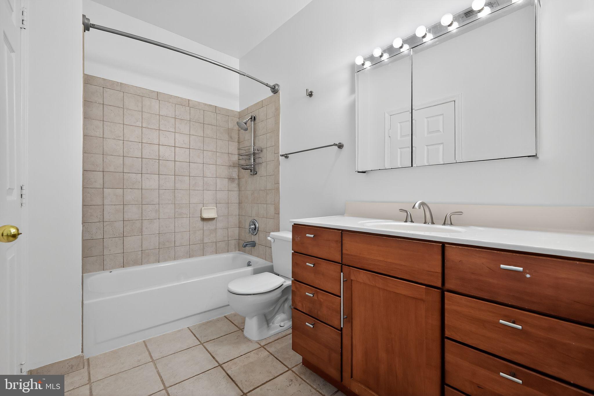12016 Taliesin Place, Unit 26 Reston, VA 20190 - Photo 25 of 30 a bathroom with a bathtub shower sink vanity and toilet