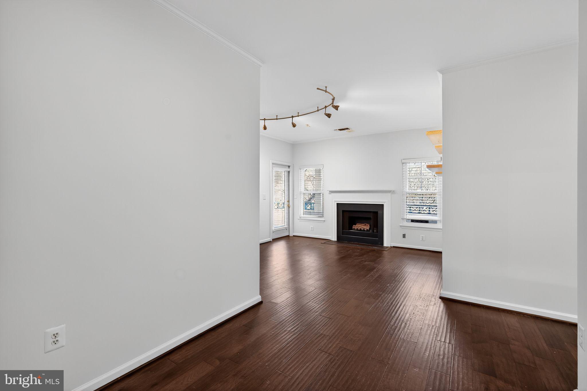 12016 Taliesin Place, Unit 26 Reston, VA 20190 - Photo 6 of 30 a view of an empty room with wooden floor fireplace and a window