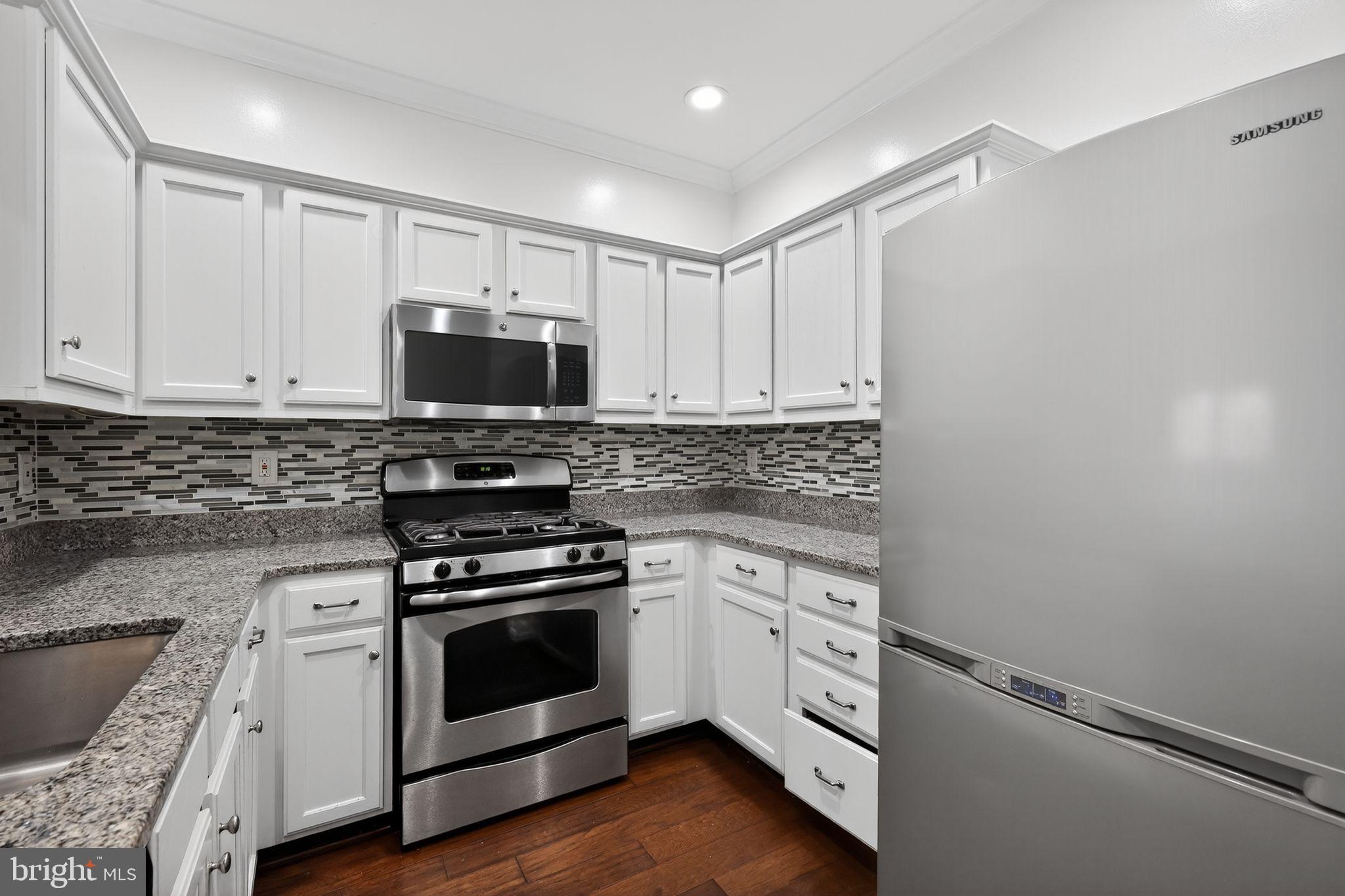 12016 Taliesin Place, Unit 26 Reston, VA 20190 - Photo 9 of 30 a kitchen with cabinets stainless steel appliances and wooden floor