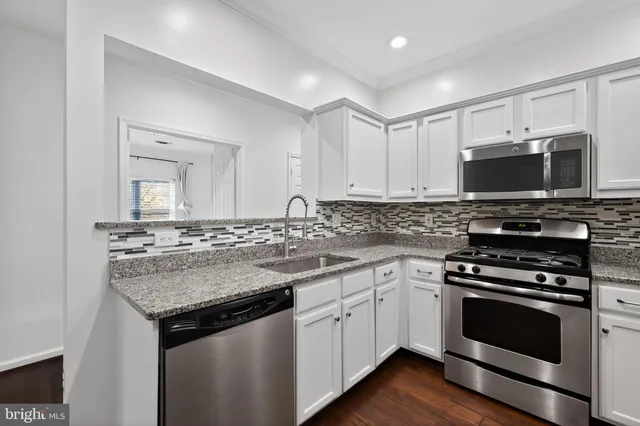 a kitchen with a sink stove and microwave