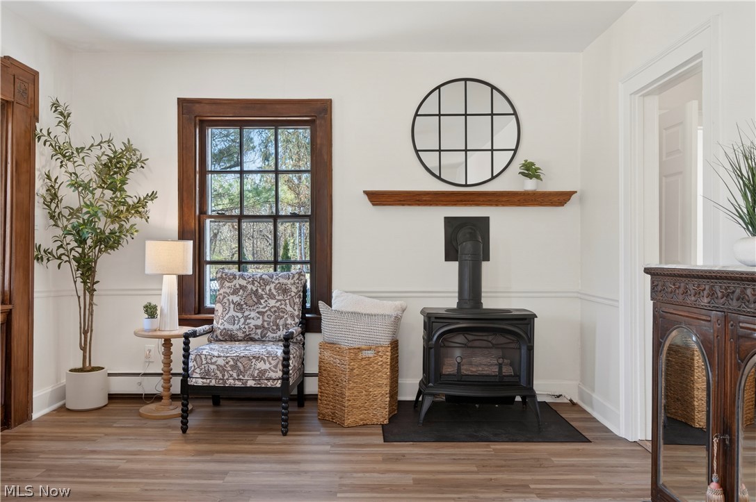 14939 Caves Road Novelty, OH 44072 - Photo 7 of 42 Living area featuring a wood stove, light wood-style flooring, a baseboard radiator, and baseboard heating
